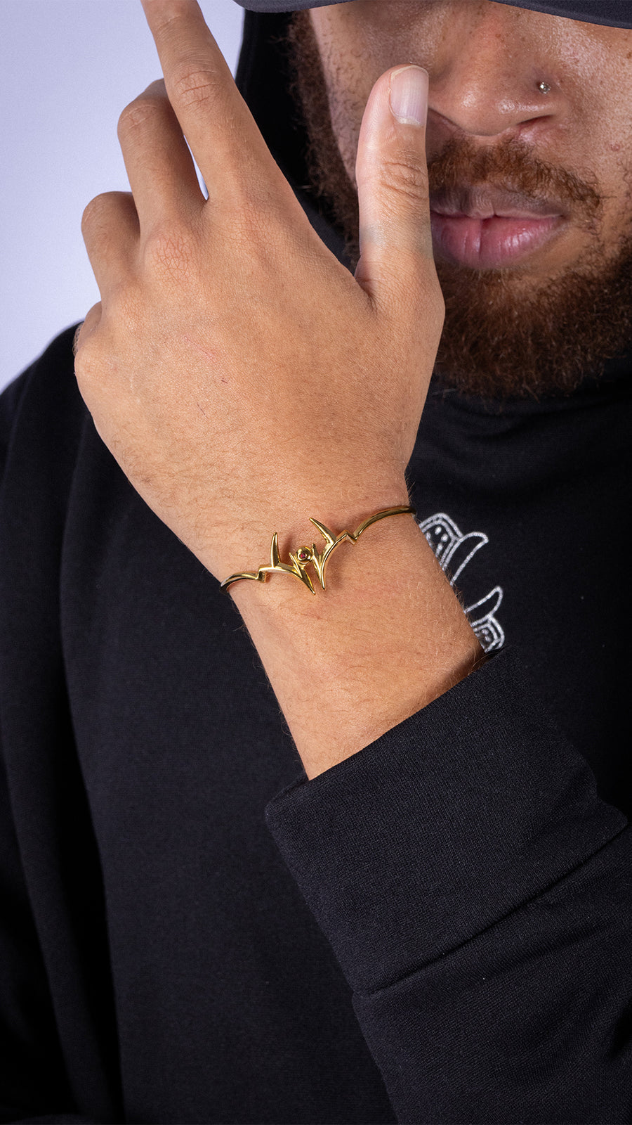 MALEVOLENT gold bracelet on wrist