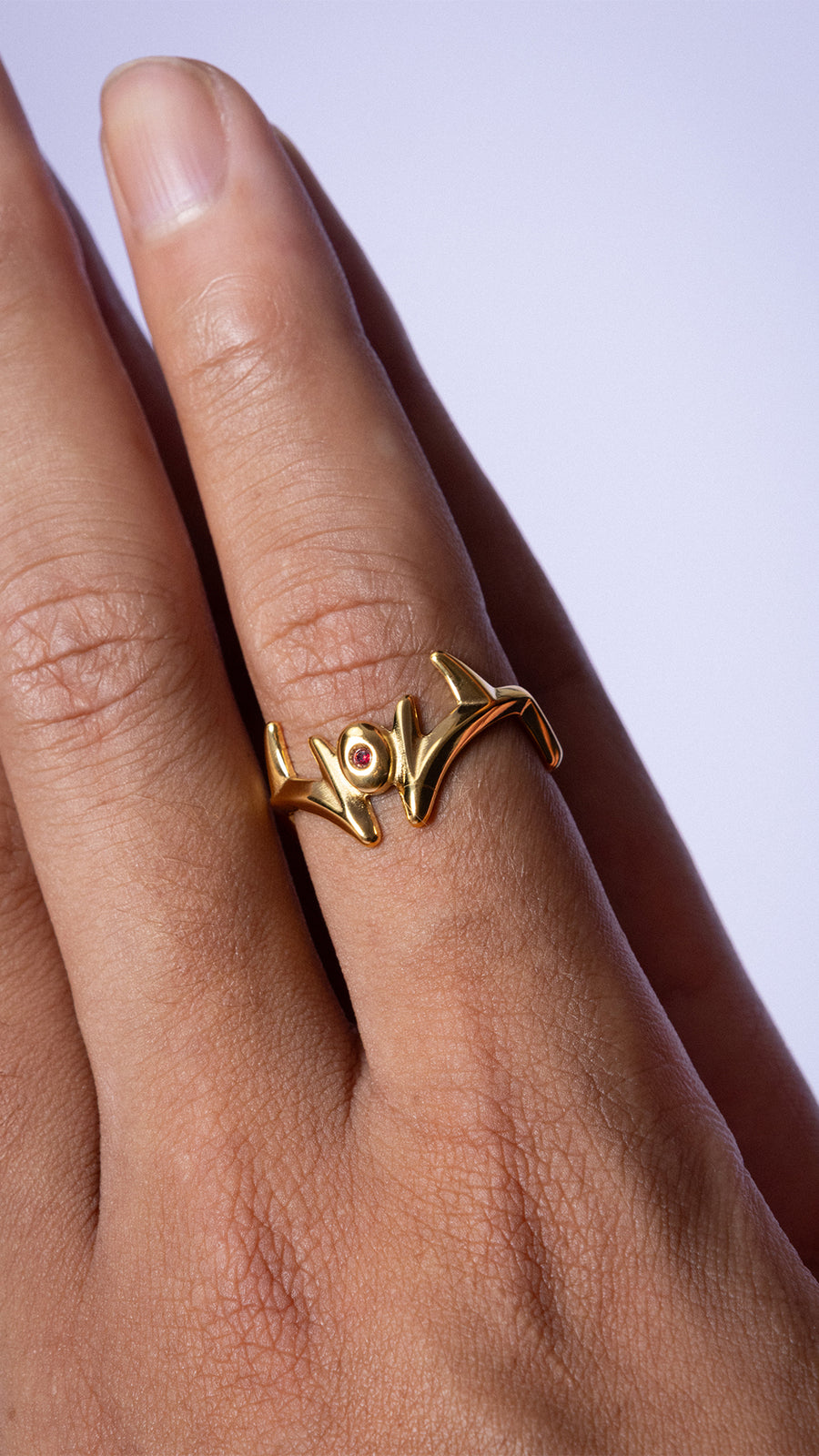MALEVOLENT gold ring worn on hand