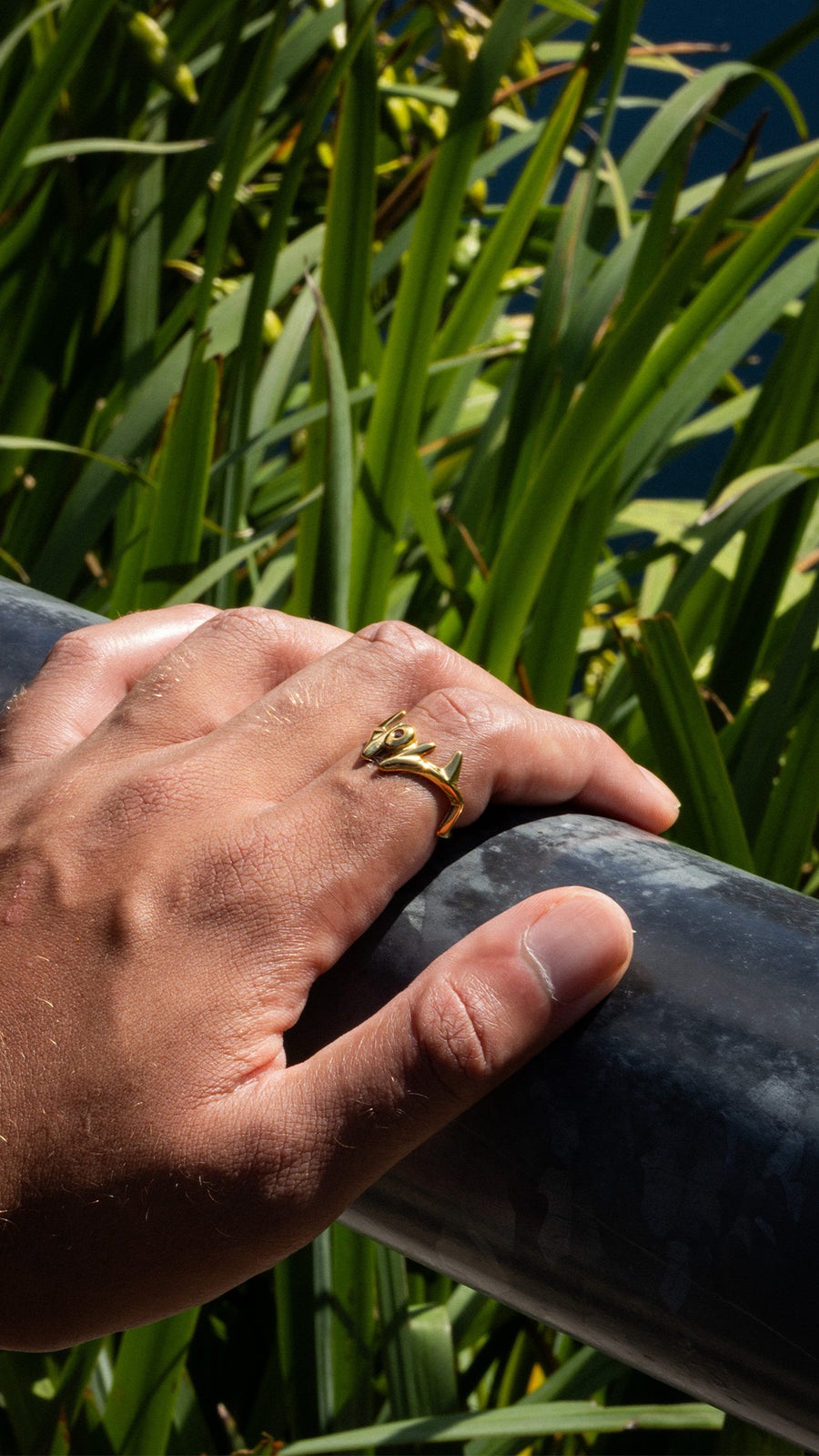 MALEVOLENT gold ring on a railing